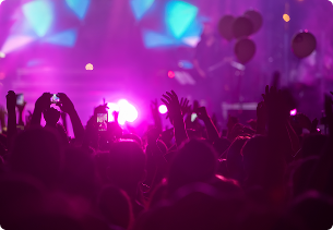 Mensen filmen het concert met hun gsm onder fel paars licht, midden in een feestelijke sfeer, tijdens een evenement met steun van X²O badkamers.